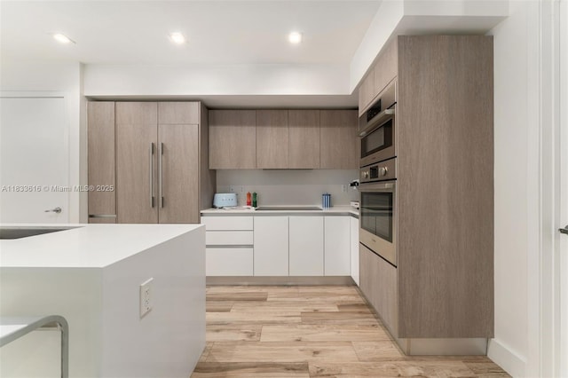 455 NE 39th St Unit 105, Miami, FL 33137 - kitchen featuring stainless steel oven, modern cabinets, light countertops, light wood finished floors, and recessed lighting