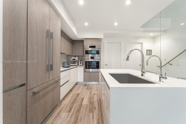 455 NE 39th St Unit 105, Miami, FL 33137 - kitchen with modern cabinets, double oven, light wood-type flooring, light countertops, and recessed lighting