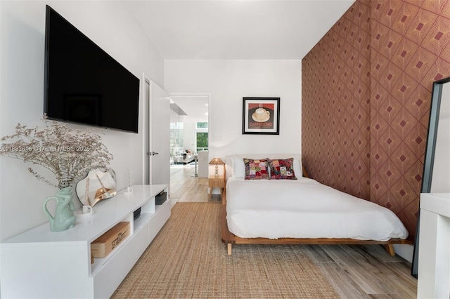 455 NE 39th St Unit 105, Miami, FL 33137 - bedroom with light wood-style flooring and an accent wall