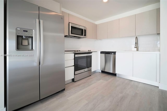 19380 NE 26th Ave Unit 304, Miami, FL 33180 - kitchen with stainless steel appliances, light wood-type flooring, light countertops, and backsplash