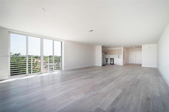 19380 NE 26th Ave Unit 304, Miami, FL 33180 - unfurnished living room with light wood-style flooring and baseboards