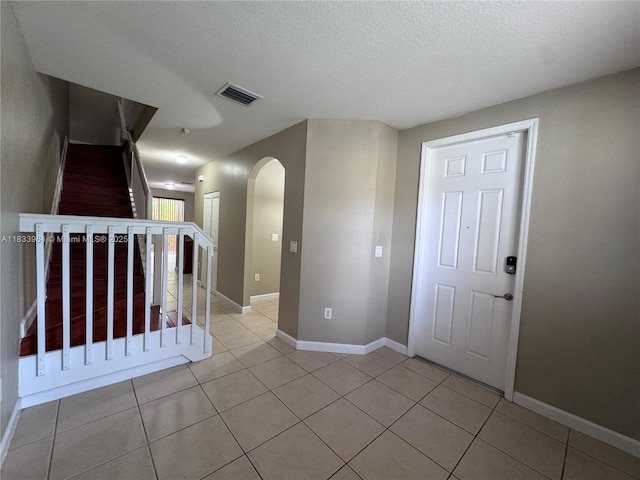 9239 SW 227th St, Cutler Bay, FL 33190 - foyer featuring arched walkways, light tile patterned floors, stairway, and a textured ceiling