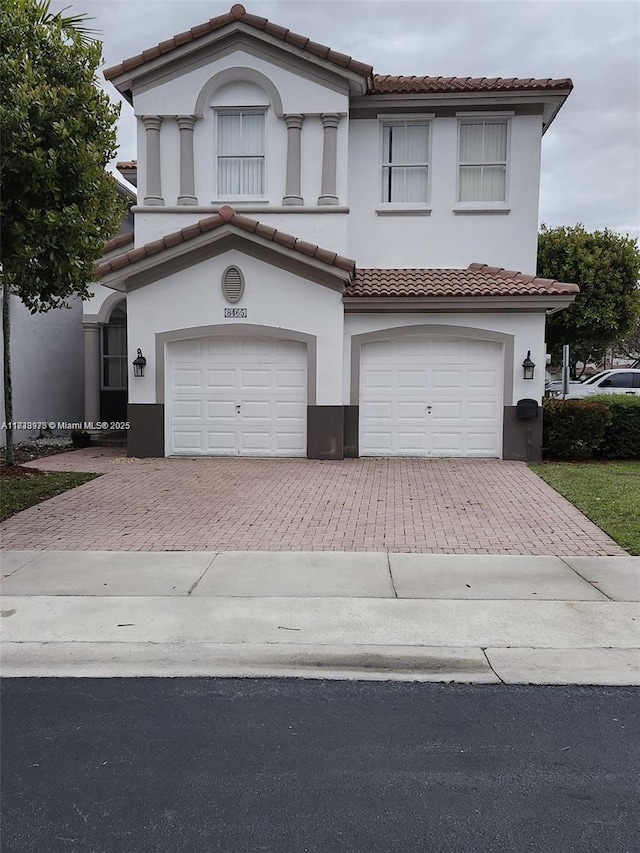 8465 NW 108th Path, Doral, FL 33178 - view of front of home with decorative driveway, an attached garage, a tiled roof, and stucco siding