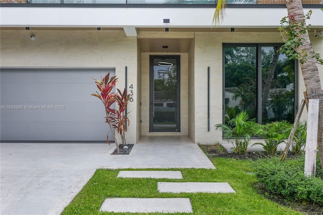 436 NE 10th Ave, Fort Lauderdale, FL 33301 - view of exterior entry with stucco siding and a garage