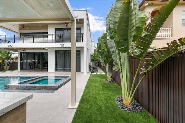 436 NE 10th Ave, Fort Lauderdale, FL 33301 - rear view of property featuring a balcony, ceiling fan, a patio, a fenced backyard, and a pool with connected hot tub