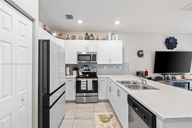 10468 W 33rd Ln, Hialeah, FL 33018 - kitchen with stainless steel appliances, a peninsula, light tile patterned floors, decorative backsplash, and light countertops