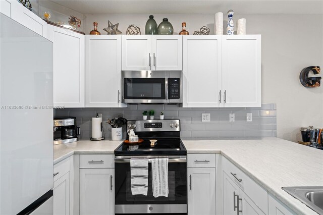 10468 W 33rd Ln, Hialeah, FL 33018 - kitchen with appliances with stainless steel finishes, white cabinets, and tasteful backsplash