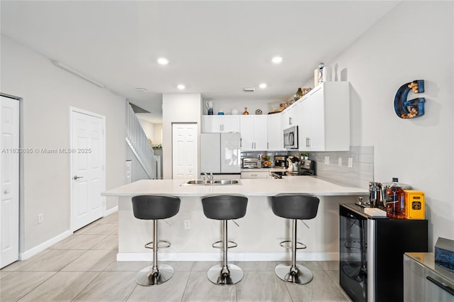10468 W 33rd Ln, Hialeah, FL 33018 - kitchen featuring stainless steel appliances, a peninsula, light countertops, a kitchen breakfast bar, and recessed lighting