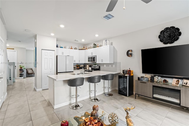10468 W 33rd Ln, Hialeah, FL 33018 - kitchen with stainless steel appliances, a peninsula, a breakfast bar, decorative backsplash, and white cabinetry
