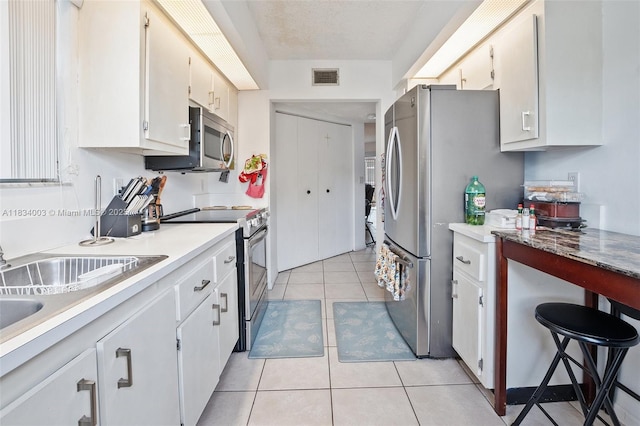 2657 SE 19th Ct Unit 103-E, Homestead, FL 33035 - kitchen featuring appliances with stainless steel finishes, light tile patterned flooring, light countertops, and white cabinetry
