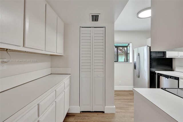 303 Gardens Dr Unit 203, Pompano Beach, FL 33069 - kitchen with stainless steel appliances, light wood-style flooring, white cabinets, and light countertops