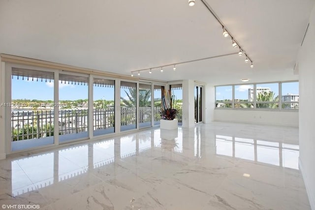 2 Grove Isle Dr Unit B410, Miami, FL 33133 - empty room with rail lighting, healthy amount of natural light, and marble tiled floors