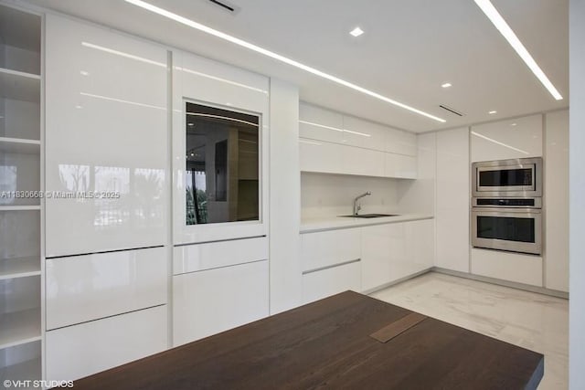 2 Grove Isle Dr Unit B410, Miami, FL 33133 - kitchen with modern cabinets, stainless steel appliances, light marble finish floors, and white cabinets