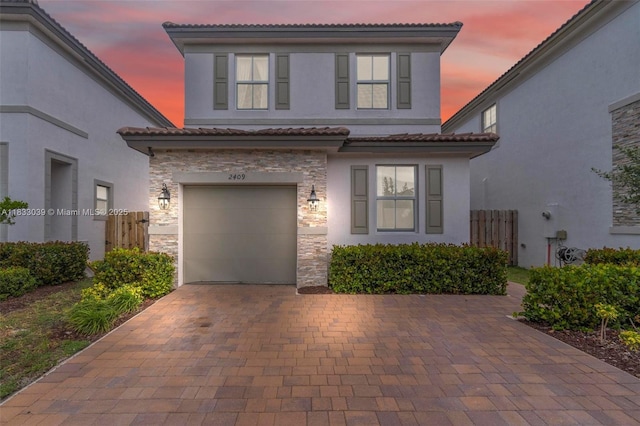 2409 NW 131st Cir, Miami, FL 33167 - view of front of property featuring an attached garage, stone siding, stucco siding, decorative driveway, and a tiled roof