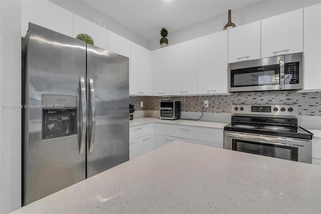 2409 NW 131st Cir, Miami, FL 33167 - kitchen with appliances with stainless steel finishes, white cabinetry, tasteful backsplash, and light stone countertops