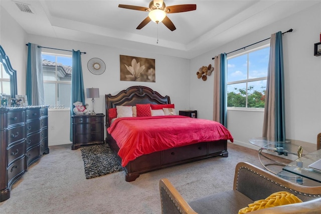 2409 NW 131st Cir, Miami, FL 33167 - bedroom featuring a tray ceiling, multiple windows, and carpet flooring
