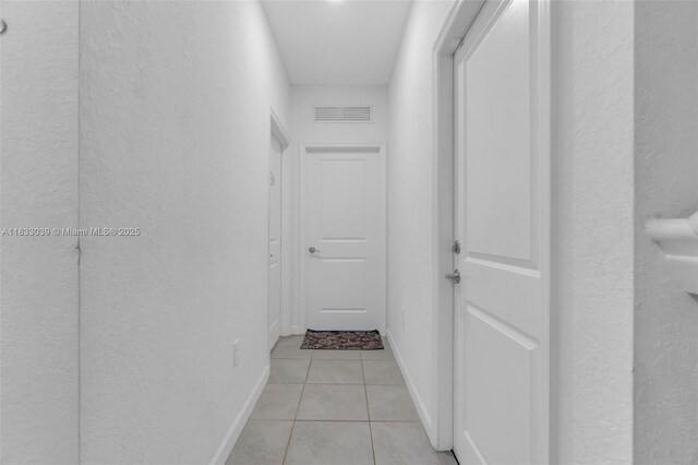 2409 NW 131st Cir, Miami, FL 33167 - hallway with a textured wall and light tile patterned floors