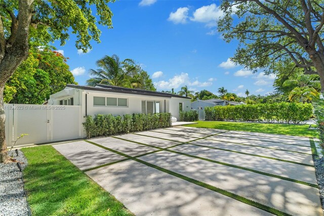 1003 NE 115th St, Biscayne Park, FL 33161 - back of property featuring stucco siding and a gate