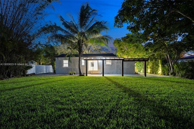 1003 NE 115th St, Biscayne Park, FL 33161 - back of property with a yard, stucco siding, and entry steps