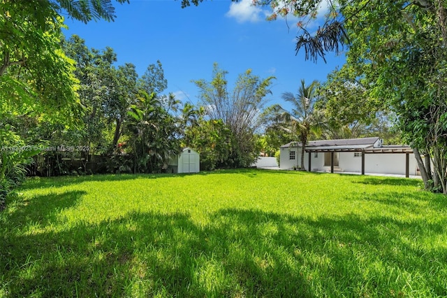 1003 NE 115th St, Biscayne Park, FL 33161 - view of grassy yard featuring a storage shed