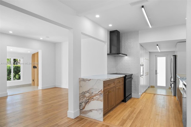 1003 NE 115th St, Biscayne Park, FL 33161 - kitchen with wall chimney exhaust hood, freestanding refrigerator, black / electric stove, light wood-type flooring, and brown cabinetry