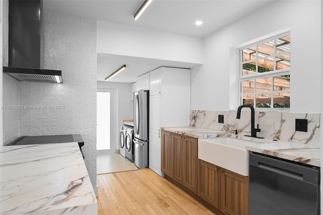 1003 NE 115th St, Biscayne Park, FL 33161 - kitchen with dishwashing machine, wall chimney exhaust hood, washing machine and dryer, stovetop, and light stone counters