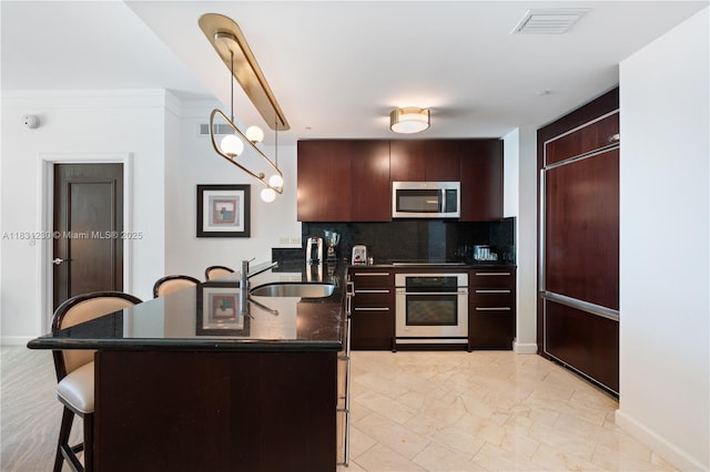 4391 Collins Ave Unit 623, Miami Beach, FL 33140 - kitchen featuring appliances with stainless steel finishes, a breakfast bar, tasteful backsplash, and light marble finish flooring