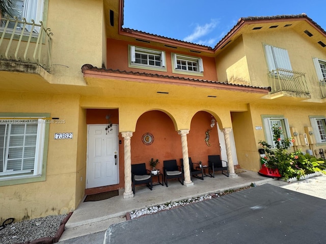 7382 SW 152nd Ave Unit 206, Miami, FL 33193 - rear view of property featuring stucco siding, a tiled roof, and covered porch