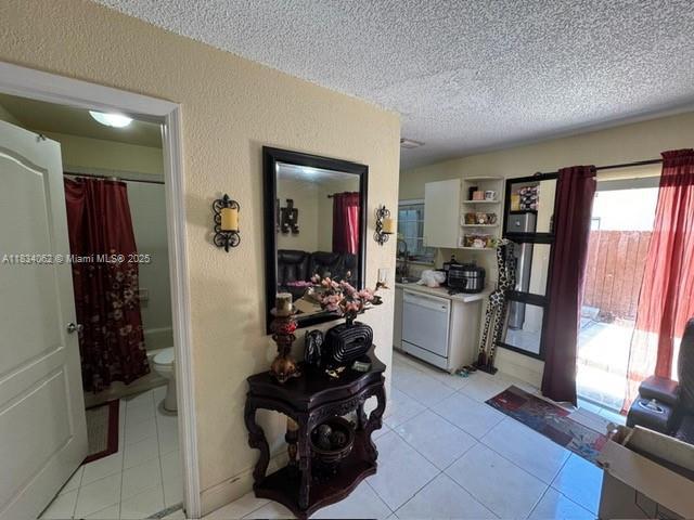7382 SW 152nd Ave Unit 206, Miami, FL 33193 - hallway with a textured ceiling, light tile patterned floors, and a textured wall