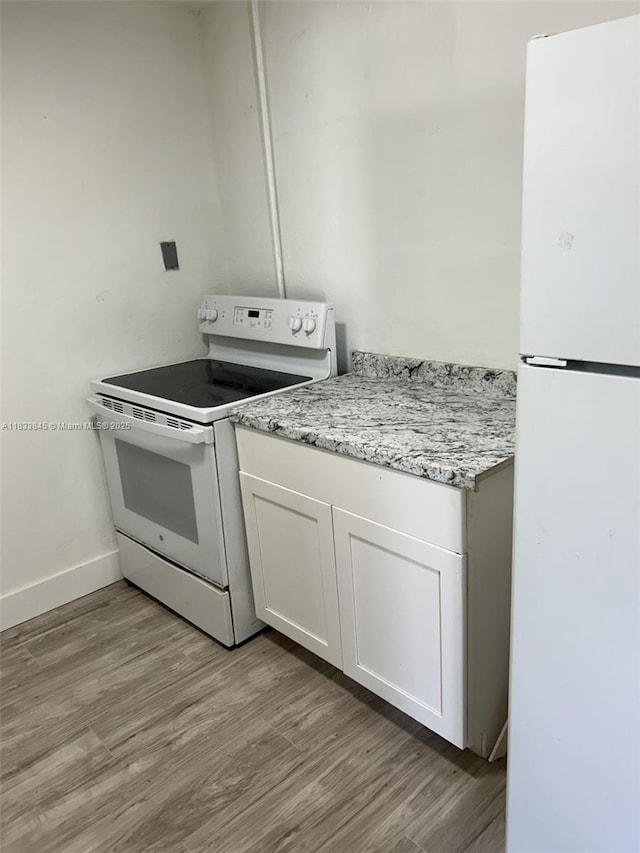 22020 SW 115th Ct, Miami, FL 33170 - kitchen with white appliances, light wood-type flooring, white cabinets, and light stone countertops