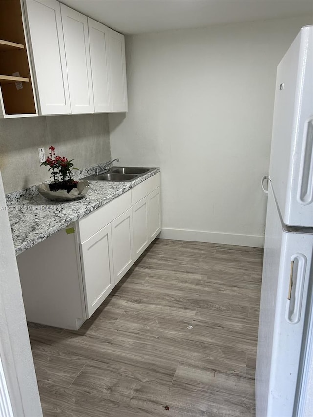 22020 SW 115th Ct, Miami, FL 33170 - kitchen featuring freestanding refrigerator, white cabinetry, wood finished floors, and light stone countertops