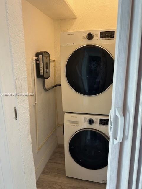 22020 SW 115th Ct, Miami, FL 33170 - laundry area with stacked washer and clothes dryer, wood finished floors, and a textured wall