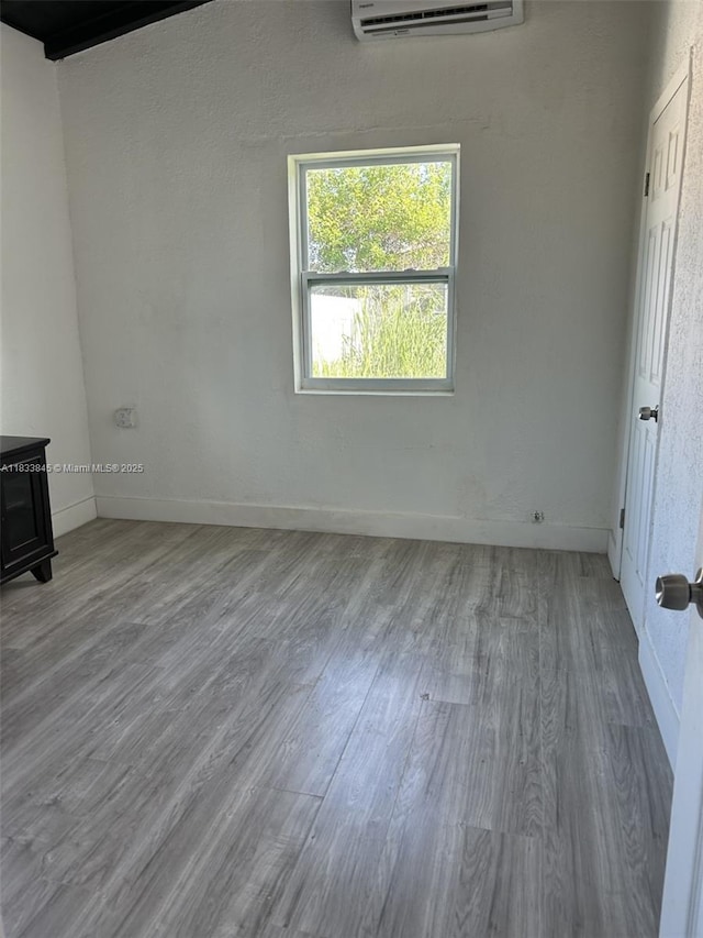 22020 SW 115th Ct, Miami, FL 33170 - unfurnished bedroom with wood finished floors, an AC wall unit, and a wood stove