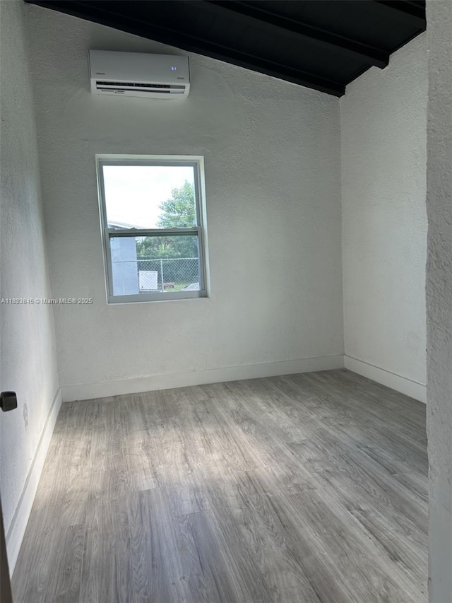 22020 SW 115th Ct, Miami, FL 33170 - empty room featuring an AC wall unit, wood finished floors, a textured wall, and beamed ceiling