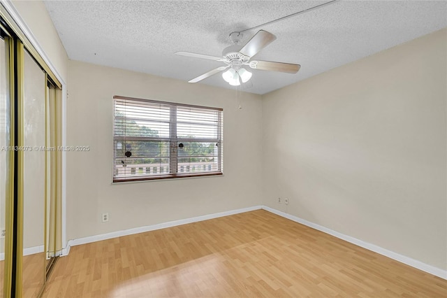1100 NW 87th Ave Unit 306, Coral Springs, FL 33071 - unfurnished bedroom featuring light wood-style floors, a textured ceiling, a closet, and a ceiling fan