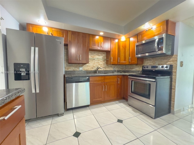 230 174th St Unit 2207, Sunny Isles Beach, FL 33160 - kitchen featuring appliances with stainless steel finishes, backsplash, dark countertops, brown cabinets, and light tile patterned flooring