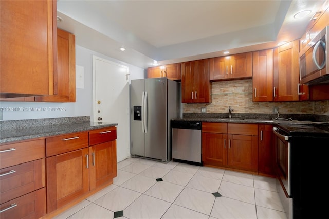 230 174th St Unit 2207, Sunny Isles Beach, FL 33160 - kitchen with stainless steel appliances, brown cabinetry, dark stone countertops, decorative backsplash, and recessed lighting