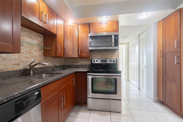 230 174th St Unit 2207, Sunny Isles Beach, FL 33160 - kitchen with appliances with stainless steel finishes, tasteful backsplash, light tile patterned floors, and dark stone counters