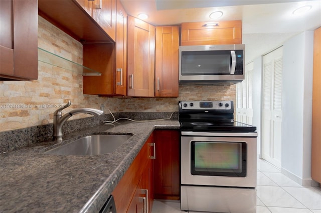 230 174th St Unit 2207, Sunny Isles Beach, FL 33160 - kitchen with appliances with stainless steel finishes, backsplash, dark stone countertops, light tile patterned floors, and brown cabinets