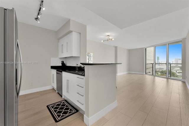 325 S Biscayne Blvd Unit 2816, Miami, FL 33131 - kitchen with stainless steel appliances, dark countertops, tasteful backsplash, a peninsula, and white cabinets