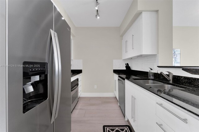 325 S Biscayne Blvd Unit 2816, Miami, FL 33131 - kitchen with stainless steel appliances, dark stone counters, tasteful backsplash, white cabinets, and light wood-style flooring