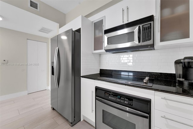 325 S Biscayne Blvd Unit 2816, Miami, FL 33131 - kitchen featuring appliances with stainless steel finishes, white cabinets, backsplash, light wood-style flooring, and glass insert cabinets