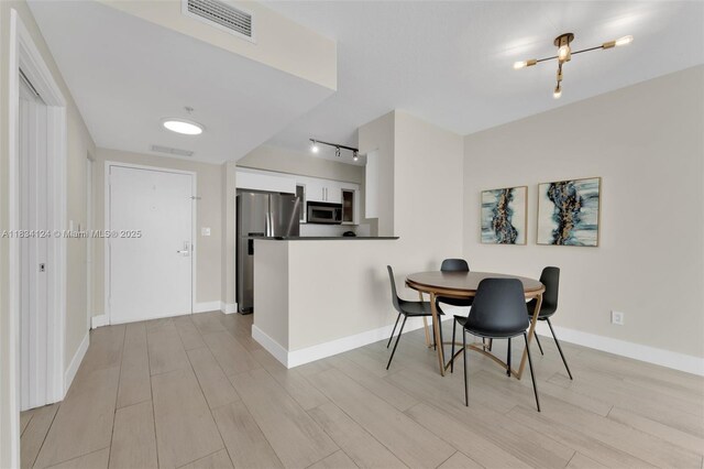 325 S Biscayne Blvd Unit 2816, Miami, FL 33131 - dining room featuring light wood finished floors and track lighting