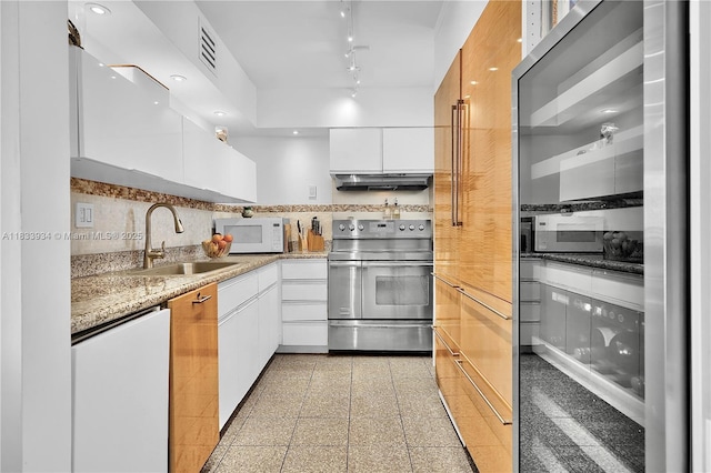 770 NE 69th St Unit 4I, Miami, FL 33138 - kitchen featuring electric stove, white microwave, under cabinet range hood, granite tiled floors, and white cabinetry