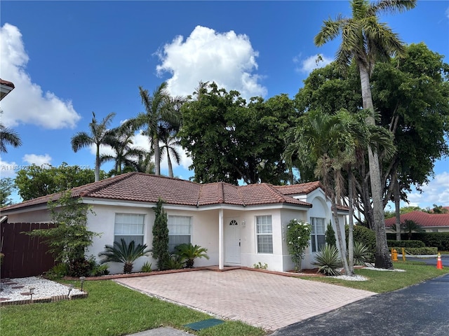 10234 NW 57th St, Doral, FL 33178 - view of front of home featuring a tiled roof, stucco siding, and a front lawn