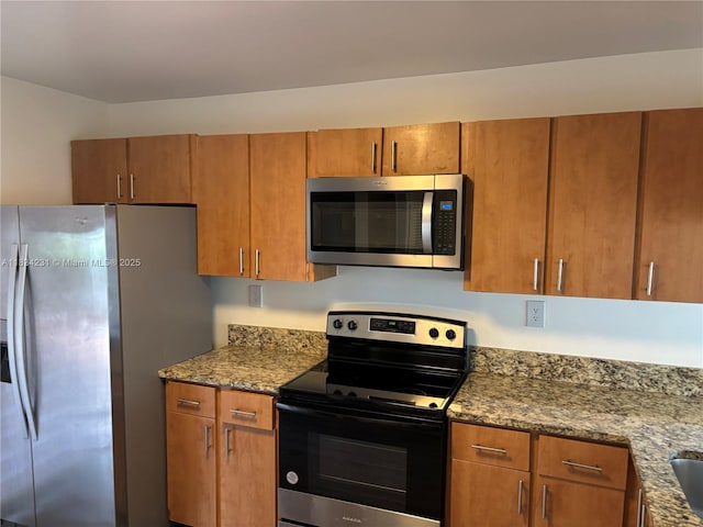 10234 NW 57th St, Doral, FL 33178 - kitchen with appliances with stainless steel finishes, brown cabinets, and stone countertops