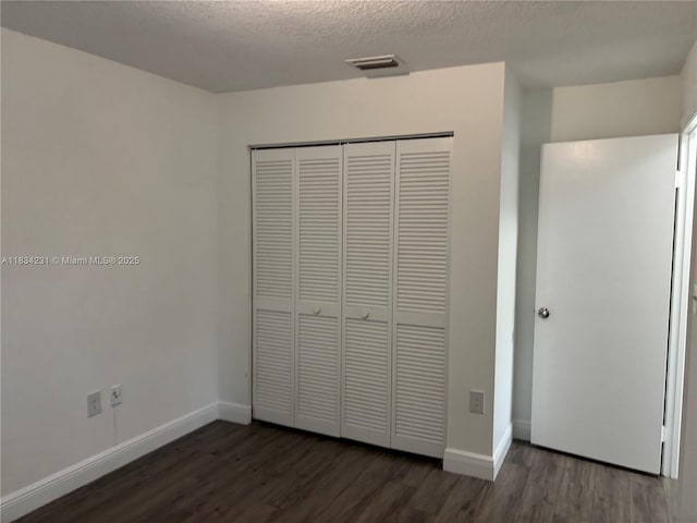 10234 NW 57th St, Doral, FL 33178 - unfurnished bedroom with wood finished floors, a closet, and a textured ceiling