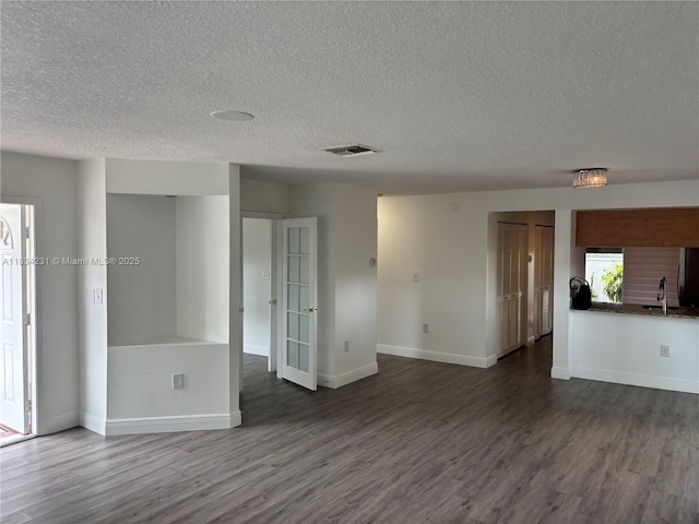 10234 NW 57th St, Doral, FL 33178 - unfurnished living room featuring dark wood-type flooring and a textured ceiling
