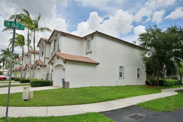 6293 SW 165th Ave, Miami, FL 33193 - view of property exterior featuring a tile roof, stucco siding, an attached garage, driveway, and a yard