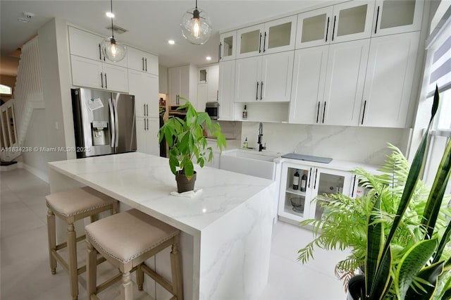 6293 SW 165th Ave, Miami, FL 33193 - kitchen with appliances with stainless steel finishes, white cabinetry, a center island, hanging light fixtures, and light stone countertops